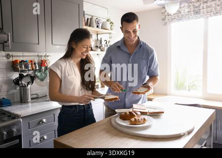 Couple preparing together morning sandwiches for breakfast Stock Photo