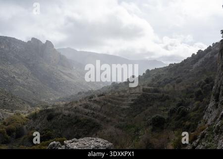 Fog and low clouds drifting over a rugged mountain valley in Parque Natural Sierra de Castril near Castril, Granada, Andalusia, Spain. Stock Photo