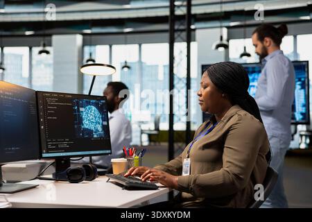 Engineer in office trains machine learning models for anomaly detection automation. Computer scientist utilizing artificial intelligence to optimize performance monitoring for immediate issue response Stock Photo