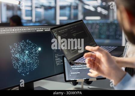 Close up of server hub software developer looking at data visualization on tablet to pinpoint performance issues. Data center worker looks at analysis graph on devices to reduce rigs malfunctions Stock Photo