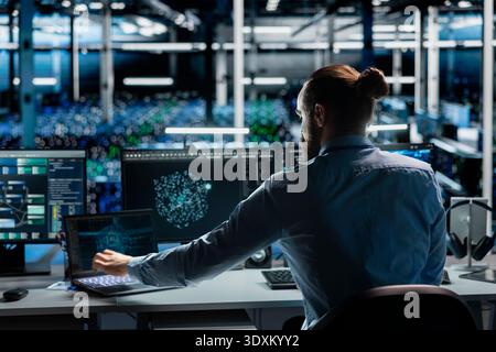 Data center computer scientist monitoring AI systems, adjusting machine learning parameters. Server room IT specialist in office enhancing artificial intelligence software performance Stock Photo