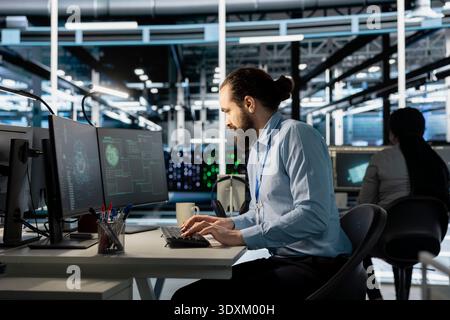 Data center worker using artificial intelligence neural networks technology on PC. Server farm facility software developer using AI programming language on computer to update hardware Stock Photo