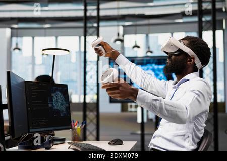 Engineer using virtual reality tech, automating repetitive tasks with AI scripts. African american man wearing VR headset using artificial intelligence to speed up feature implementation Stock Photo