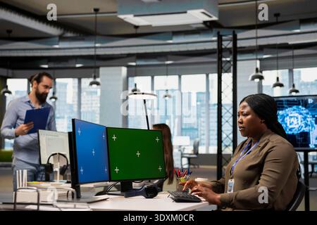 Admin using isolated screen computer at work to train machine learning models for anomaly detection automation. IT expert using AI on chroma key PC in office to repair network issues Stock Photo