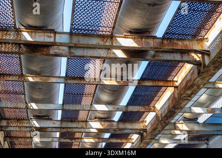 Metal roof panels rusting with sunlight in industrial structure. Stock Photo