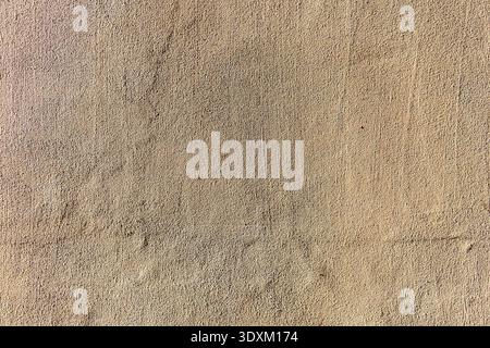 Textured beige stucco wall with subtle cracks and grain. Stock Photo