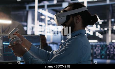 Data center employee wearing VR headset using artificial intelligence neural networks technology. Server farm programmer using AI programming language and virtual reality to update hardware, camera A Stock Photo