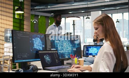 Female programmer in office integrating AI machine learning systems to streamline workflows. IT worker uses neural networks artificial intelligence, technology overload concept, camera A Stock Photo