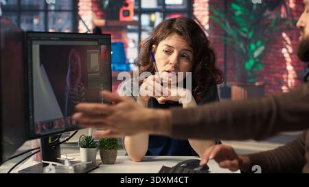 Professional photo editor interacting with retouching software on dual monitors, using professional color grading tools to create high quality images. Photography industry. Camera B. Stock Photo
