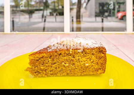 a piece of carrot cake with its characteristic golden-orange hue, showcasing visible pieces of grated carrot, walnuts, and raisins, topped with a gene Stock Photo