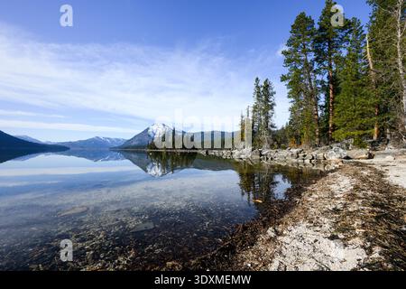 Shoreline of Lake Wenatchee in Cascade Mountains on calm spring day with reflection Stock Photo