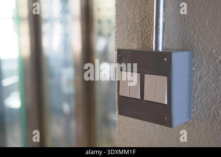Light switch mounted on a wall in a building corridor Stock Photo