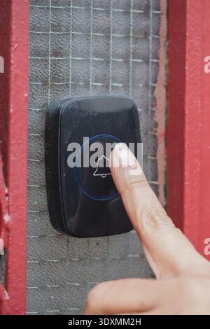 Person presses doorbell at a house entrance Stock Photo