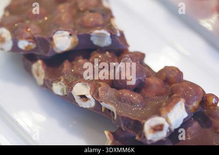 Chocolate bar with nuts on a white plate Stock Photo