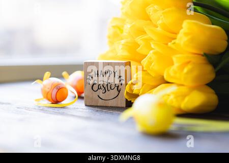 Spring festive composition with yellow tulips and decorative eggs Stock Photo