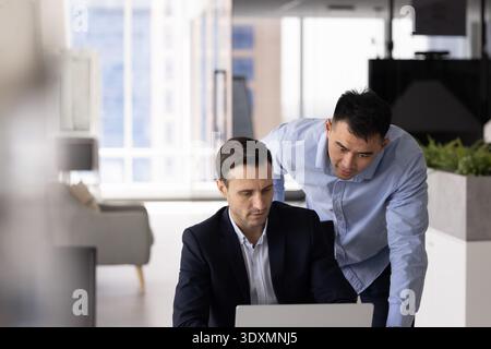 Diverse colleagues team leader worker using laptop at workplace desk Stock Photo