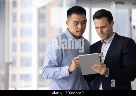 Multiethnic team two business professionals using digital tablet in office Stock Photo