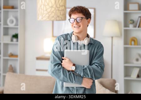 Young man in eyeglasses with laptop at home Stock Photo