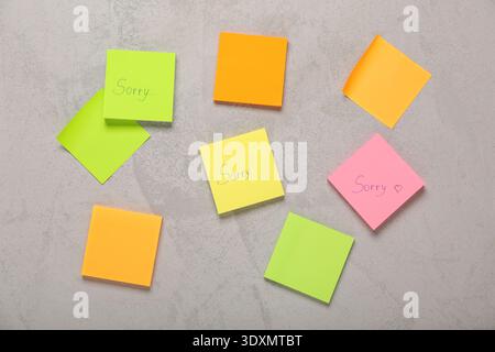 Sticky notes with word SORRY on grunge background Stock Photo