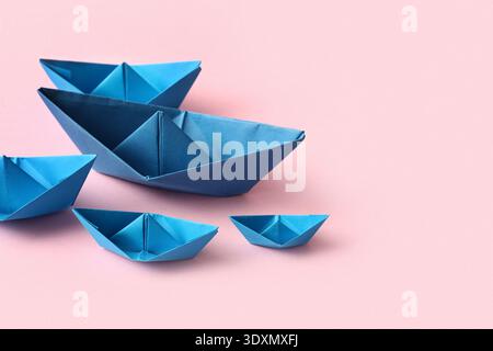 Blue paper boats on pink background Stock Photo