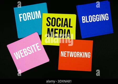 Colorful sticky note with text "Social Media, Forum, , Blogging, Website, and Networking" on a black background, various components of online communic Stock Photo