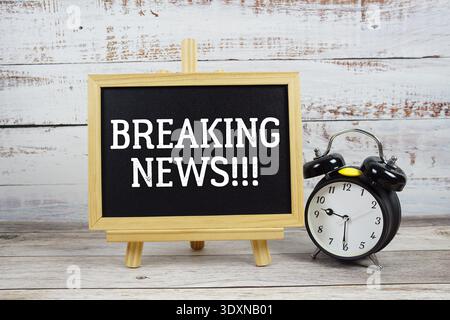 Breaking News!!! text written on blackboard with alarm clock on wooden background Stock Photo