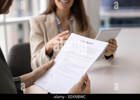 Close up image of female holding and reading printed contract Stock Photo