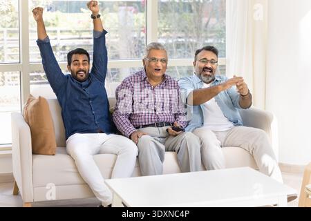 Three Indian men watching sport game match Stock Photo