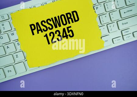 Yellow paper with text "Password 1234" placed on a white keyboard Stock Photo