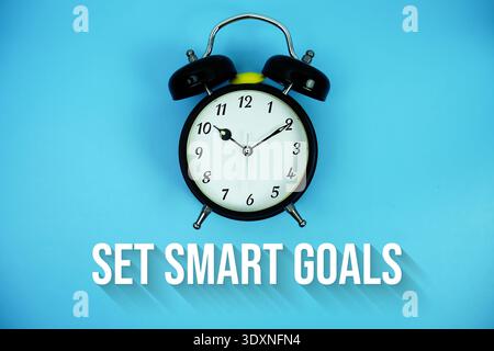 Set Smart Goals text and alarm clock on blue background Stock Photo