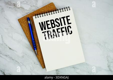 Website Traffic text written on notepad with pen on marble background Stock Photo