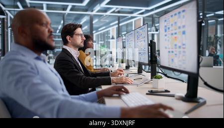 Group Of Diverse Designers Collaborating On App Development And User Interface. A Young Woman Working On UX Design Stock Photo