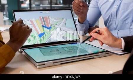 Diverse Group Of Engineers And Architects Use Digital BIM Software To Map Real Estate Sites On Tablets And Laptops Stock Photo