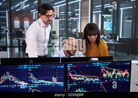 Diverse Group Of People In Business Meeting Discussing Stock Charts Stock Photo