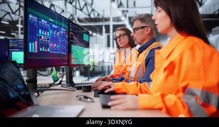 Technician In Modern Industrial Control Room Monitors SCADA For Automation. Stock Photo