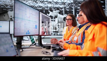 Senior Engineer And Technician Using Advanced PC Technology In Factory. Stock Photo