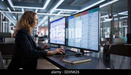 Agile Office Woman Managing Tasks On Computer Monitor Screen Stock Photo
