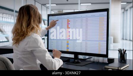 Female Chartered Accountant Analyzing Financial Data On Computer Spreadsheet Stock Photo