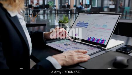 Female Financial Analyst Analyzing KPI Data On Laptop Screen Stock Photo