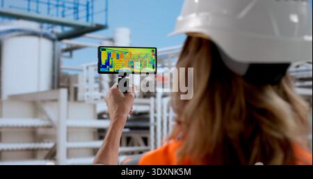 Female Engineer Inspecting Gas Pipeline With Thermal Imaging Camera Stock Photo