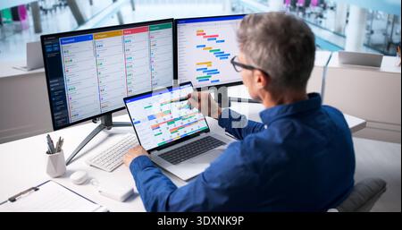 Older Caucasian Man Manages Business Event Scheduling Software On Desktop. Stock Photo