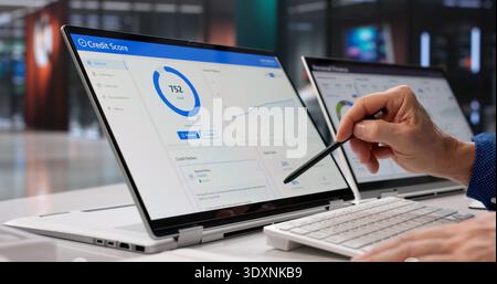 Businessman Analyzing Credit Score Online Using Laptop In Modern Office Stock Photo