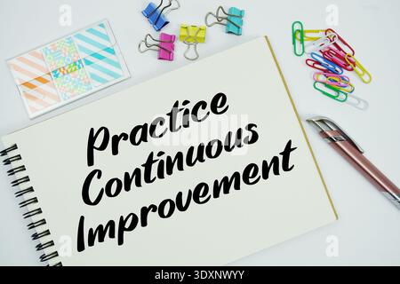Practice Continuous Improvement text message written on notepad with stationery flat lay on white background Stock Photo