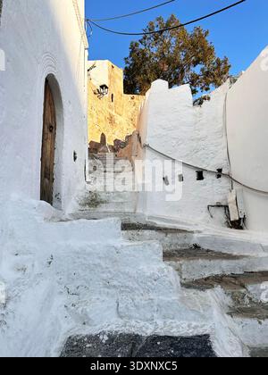 Narrow streets and stone steps are typical of the paths leading up to the Acropolis in the village of Lindos. Rhodes, Greece Stock Photo