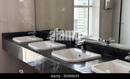Modern bathroom with sleek black marble countertops and white sinks. High quality photo Stock Photo