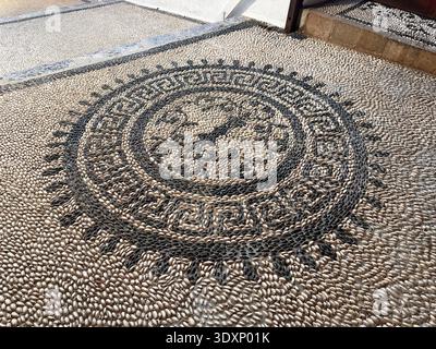 The pebbled pavements with small stones are traditional floors in the Greek islands Stock Photo