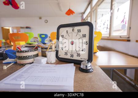 Clock and papers on an office desk in a modern room, bright windows, homework supervision, Schlehengaeu Grund Schule Gechingen, Calw district, Germany Stock Photo