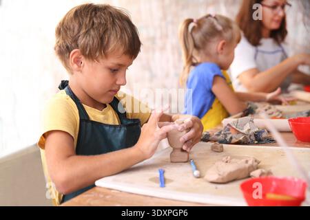 Kids molded from clay at pottery class. || Model released Stock Photo