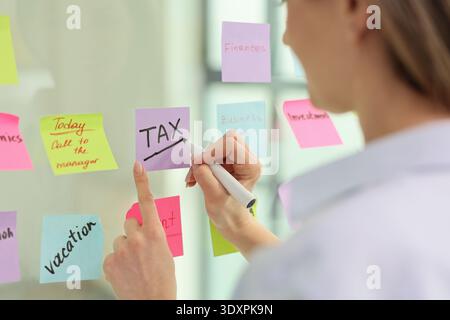 Creative planning session focuses on tax deadlines with colorful sticky notes in a modern office setting Stock Photo