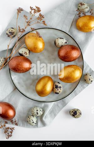 Golden and bronze Easter eggs in a orange plate Stock Photo